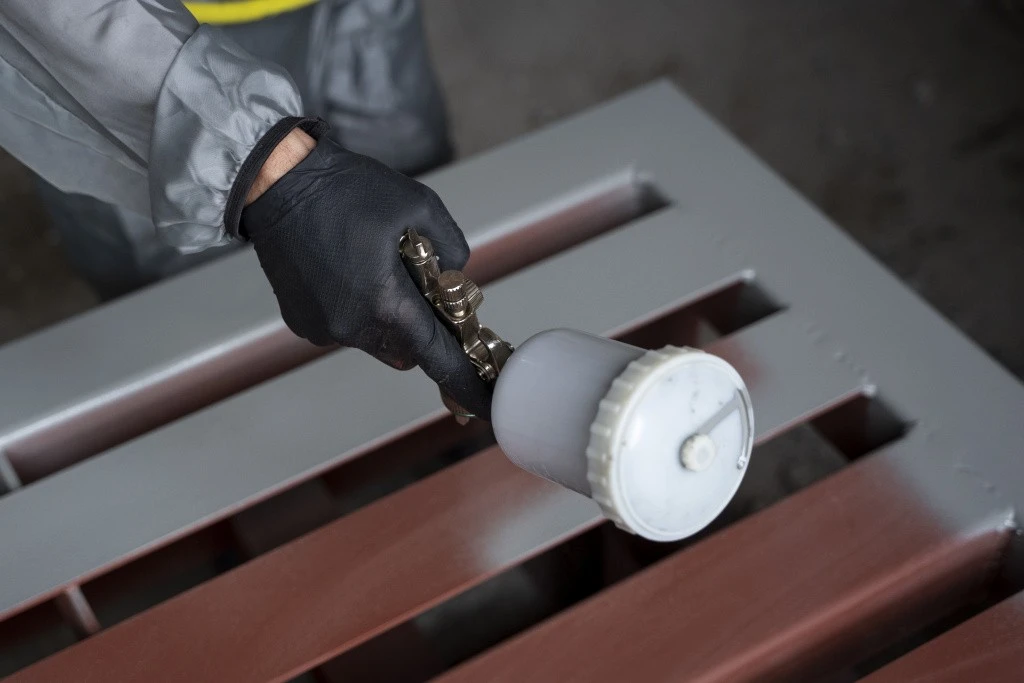 high-angle-worker-spraying-powder-paint-from-gun.jpg